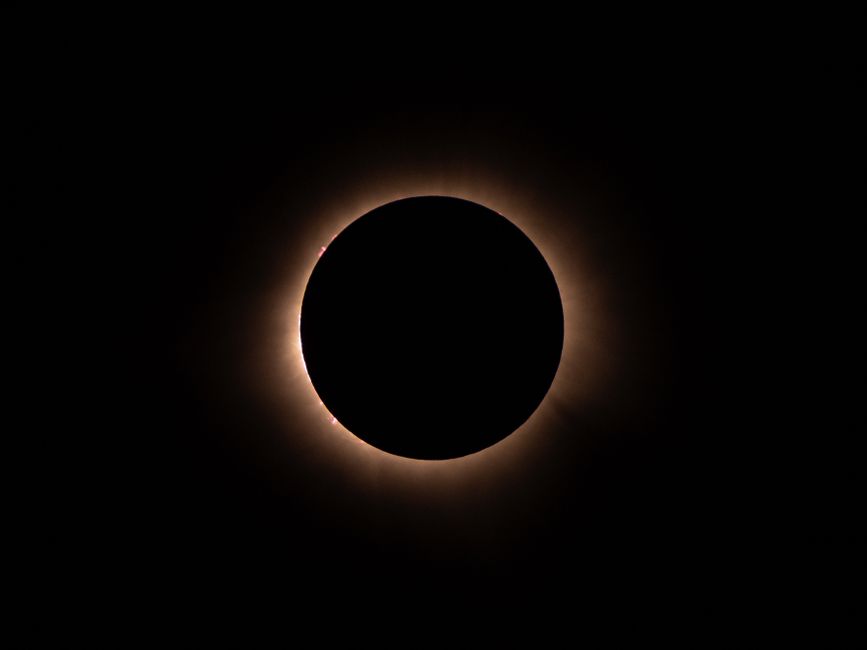 Corona solar visible durante un eclipse total con el cielo oscurecido
