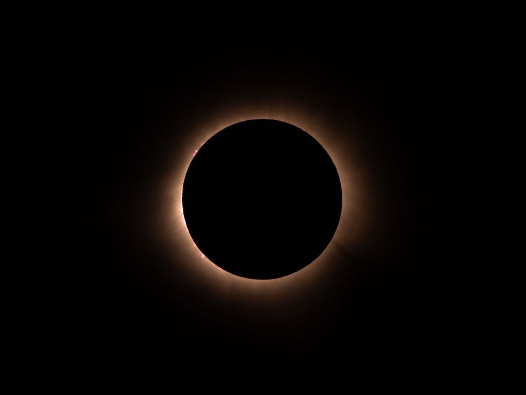 Eclipse total de Sol con la corona brillando alrededor del disco lunar.