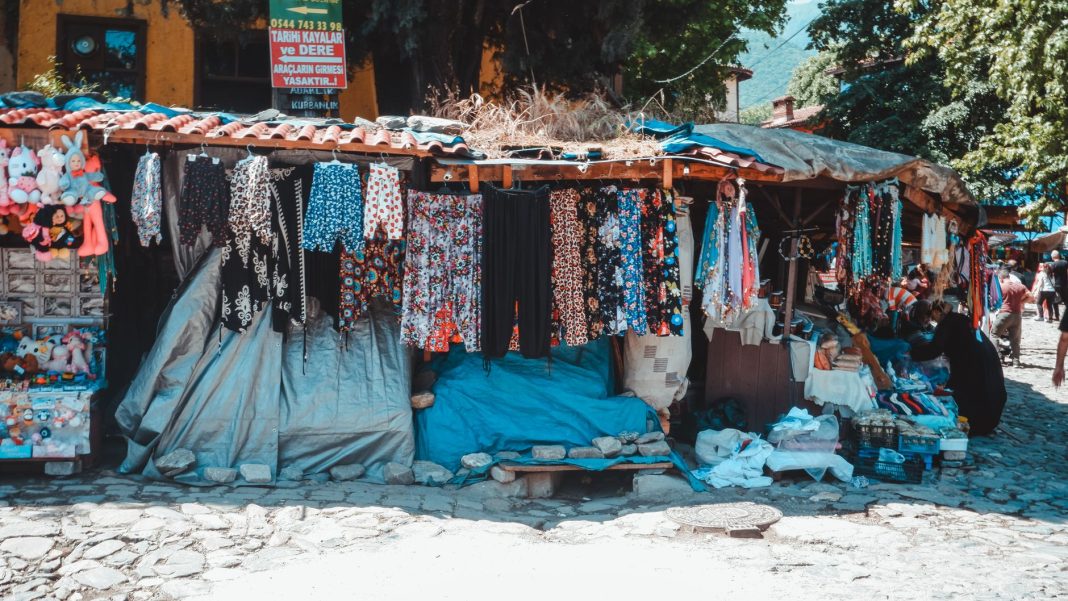 Puesto de un mercadillo al aire libre con género expuesto.
