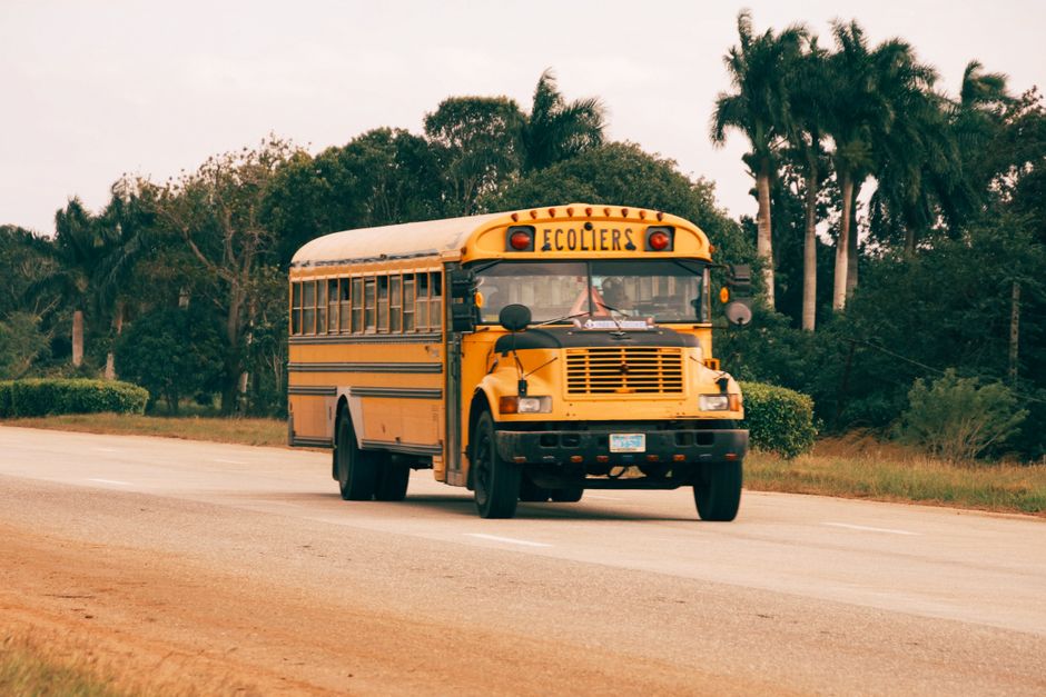 Autobús escolar circulando por carretera rural
