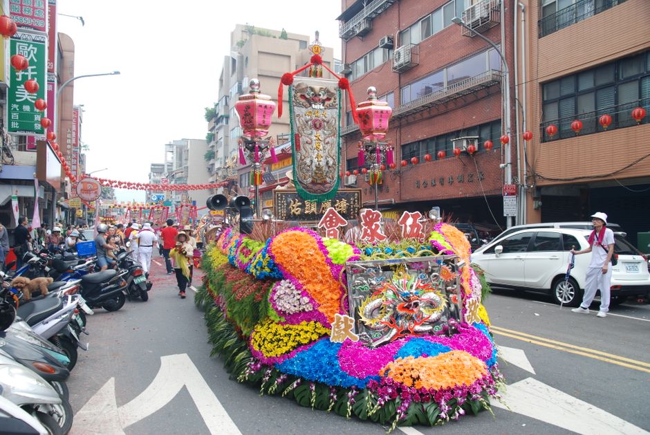 Carroza decorada con motivos artísticos en un desfile festivo urbano