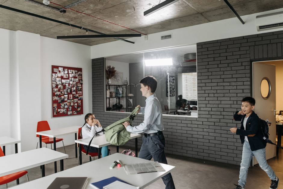 Interior de un aula escolar moderna con ventanas amplias y equipamiento educativo