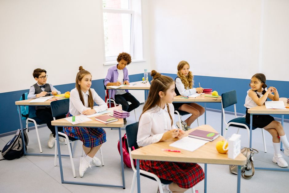 Aula de colegio vacía con pupitres y pizarra